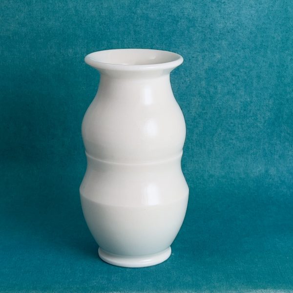 Vase blanc à double renflement Vase en porcelaine blanche brillante, col évasé et corps à deux renflements, sur fond turquoise.