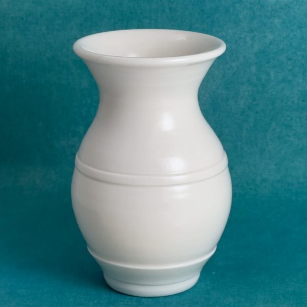 Vase classique à col évasé Vase blanc en porcelaine avec un col évasé, un corps arrondi et une fine ligne à mi-hauteur, sur fond turquoise.